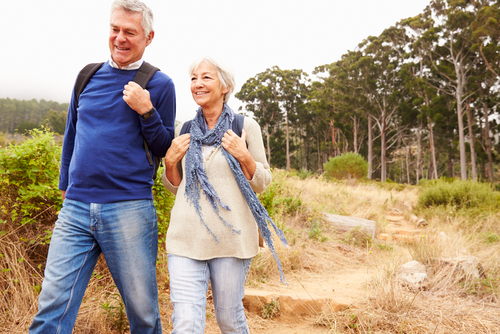 Older couple walking in trail in the woods