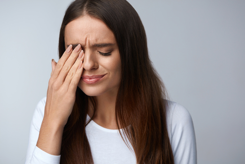 A woman in distress covering one of her eyes