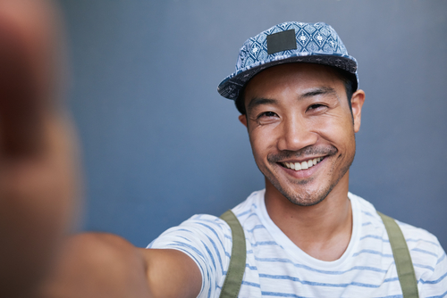 man smiling while taking a selfie