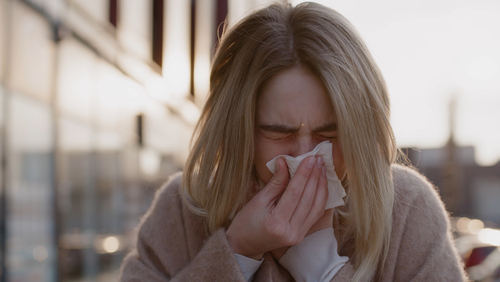 Woman blowing nose