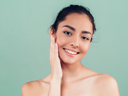 woman touching face after microneedling