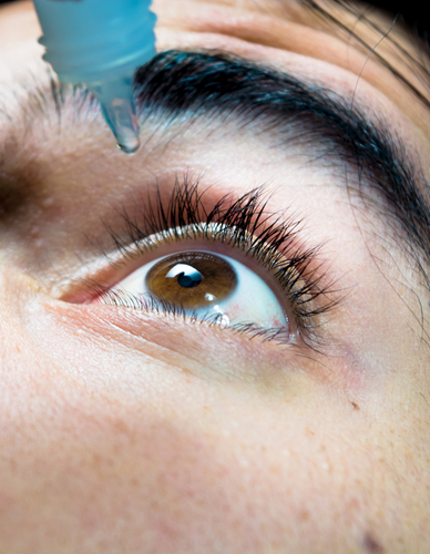 woman putting in eye drops